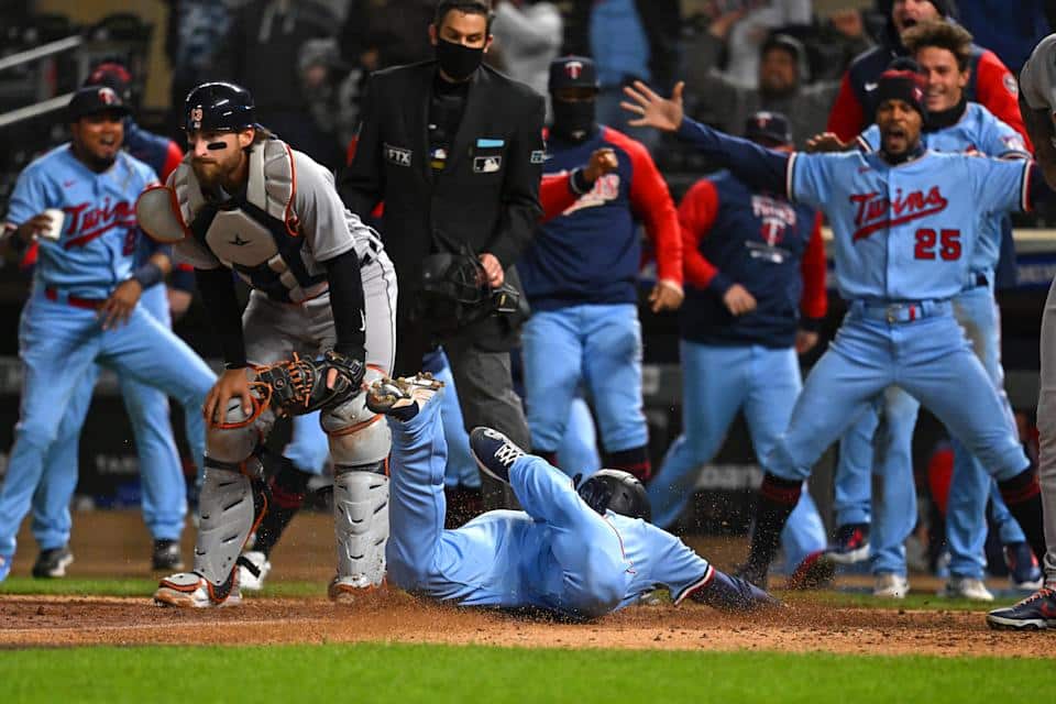 April 26, 2022;  Minneapolis, Minnesota, United States;  Minnesota Twins third baseman Gio Urshela (15) slides home for the game-winning run as teammates celebrate after a throwing error by Detroit Tigers catcher Eric Haase (13) during the ninth inning at Target Field.  Mandatory Credit: Nick Wosika-USA TODAY Sports