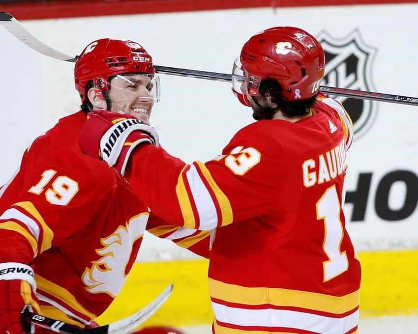 Calgary Flames left wing Johnny Gaudreau (13) celebrates scoring the 100th point of the season with teammate left wing Matthew Tkachuk during third period NHL hockey action against the Seattle Kraken at Calgary on Tuesday, April 12, 2022.
