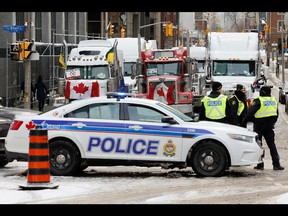 Police patrol a barricade as vehicles block downtown streets as truckers and supporters continue to protest coronavirus disease (COVID-19) vaccination mandates in Ottawa, Ontario, Canada, on February 3, 2022.