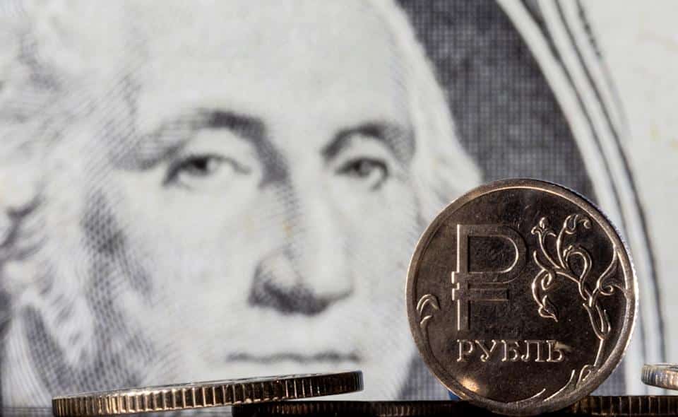 Russian ruble coins are seen against the US dollar bill in this illustration taken on February 24, 2022. REUTERS/Dado Ruvic/Illustration