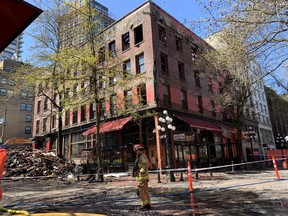 A fireman walks in front of the Winters Hotel at 203 Abbott and Water Streets Friday.  The 1907 hotel had a devastating fire April 11, and is being demolished.  But a body has been found in the ruins and demolition was temporarily halted Friday.