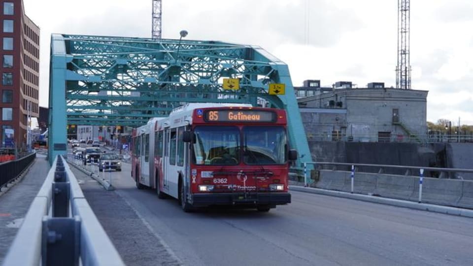 An OC Transpo bus runs on the Terrasse des Chaudières point in the direction of Gatineau. 