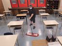 A custodian cleans a classroom at Kennedy Collegiate Institute in Windsor in this February 2021 file photo.