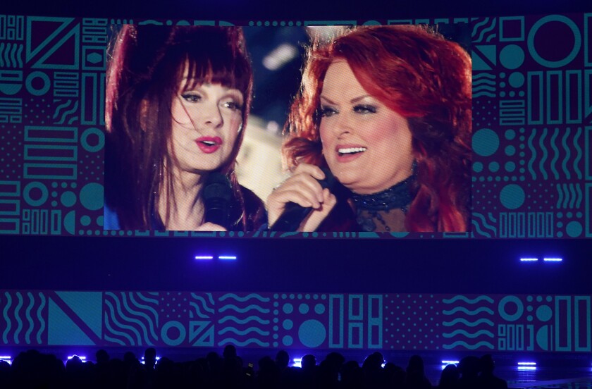 A screen that projects two women singing together.