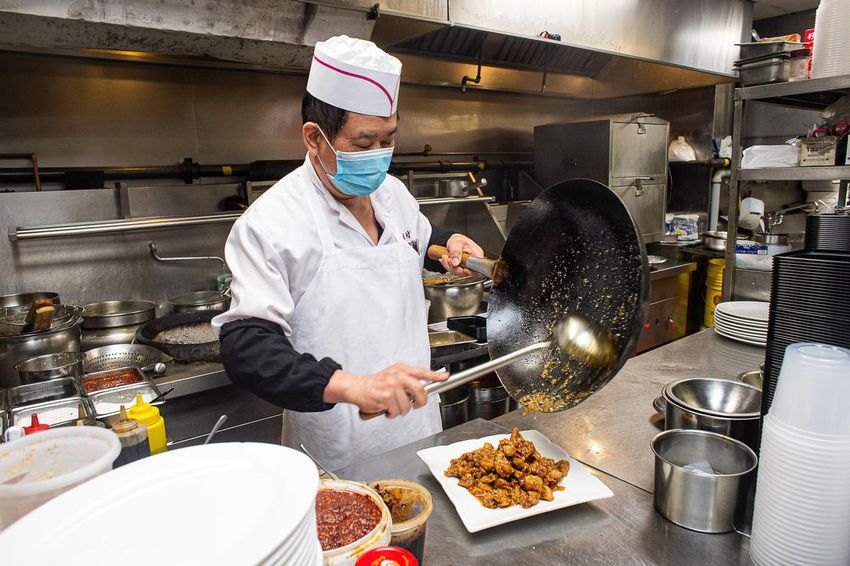 Asian Legend chef Ai Fu Wang finishes preparing general tao chicken.