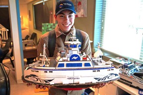 Joshua Yeung holding ferry replica he built at school.  Joshua Yeung, who was diagnosed with autism at 15, built his own fleet of ferries using household items including cardboard, toothpicks, and straws for high school projects.  Joshua works for BC Ferries as a deckhand.