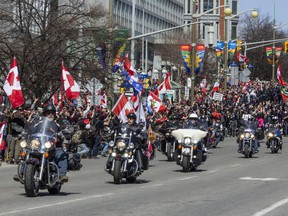 A wave of motorcycles pass in front of thousands of supporters as they complete their route for the 'Rolling Thunder' convoy on Elgin St. between Albert St. and Laurier St. on Saturday.
