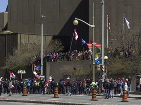 A crowd of supporters of the 'Rolling Thunder' made their way on the National Art Centre to wave their flags and chant as the convoy of motorcycles approaches Elgin St. on Saturday morning.