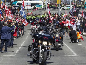 A wave of motorcycles pass in front of thousands of supporters as they complete their route for the 'Rolling Thunder' convoy on Elgin St. between Albert St. and Laurier St. on Saturday.
