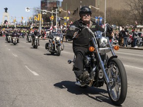 A motorcycle rider smiles to the crowd of supporters as the 'Rolling Thunder' convoy ride down Elgin St. on Saturday.