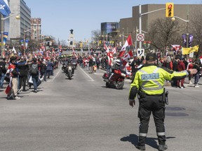 A police officer directs the convoy of the 'Rolling Thunder' to Laurier St. on Saturday.