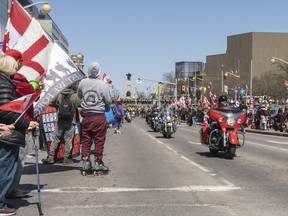 A wave of motorcycles pass in front of thousands of supporters as they complete their route for the Rolling Thunder convoy on Elgin St. between Albert St. and Laurier St. on Saturday.