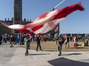 A demonstrator waves a giant Canadian flag on Parliament Hill during the 'Rolling Thunder Ottawa' event on Saturday afternoon.