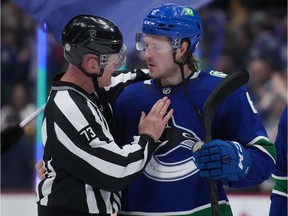 Linesman Vaughan Rody, of Winnipeg, Man., who is retiring from officiating, shares a moment with Vancouver Canucks' Brock Boeser before leaving the ice after the Vancouver and the Dallas Stars played an NHL hockey game in Vancouver, BC, Monday, April 18 , 2022.