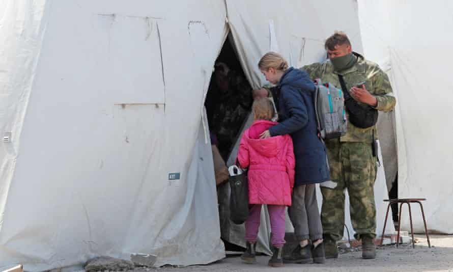 Civilian evacuees enter a tent at a temporary accommodation centre in Bezimenne.