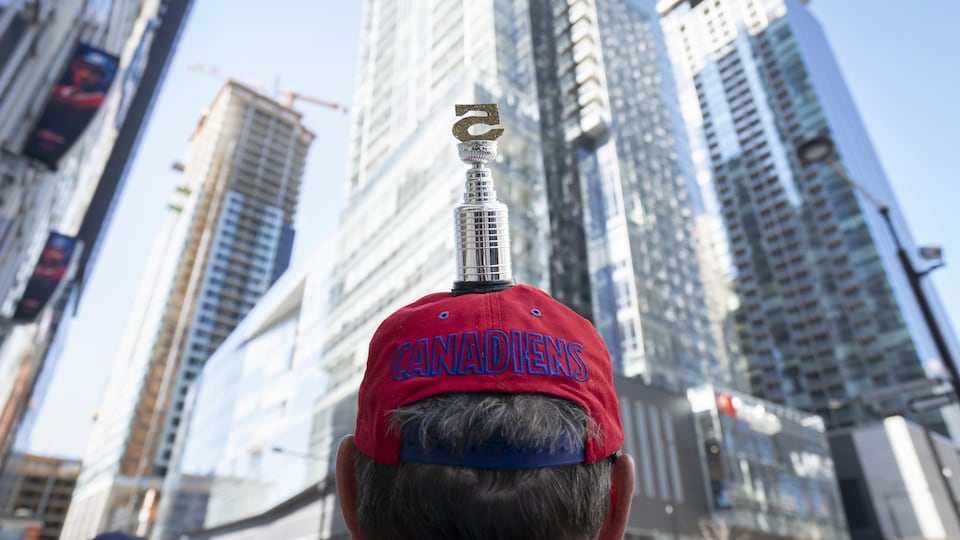 A man wearing a cap with the Stanley Cup marked with the number five.