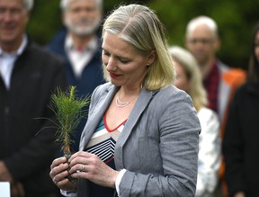 Then Minister of Environment and Climate Change Catherine McKenna holds a sapling during a funding announcement to support Forests Ontario in planting 50 million trees by 2025, on World Environment Day at the Dominion Arboretum in Ottawa on Wednesday, June 5, 2019. THE CANADIAN PRESS/ Justin Tang
