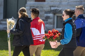Cadets carry flowers at the Royal Military College in Kingston, Ontario on Friday April 29, 2022. THE CANADIAN PRESS/Lars Hagberg