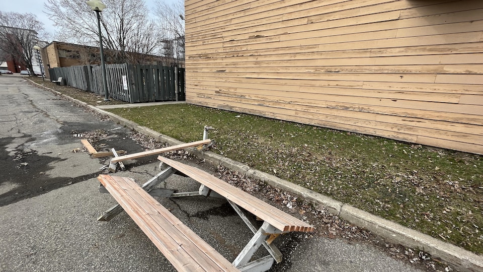 A broken picnic table in a hotel parking lot.