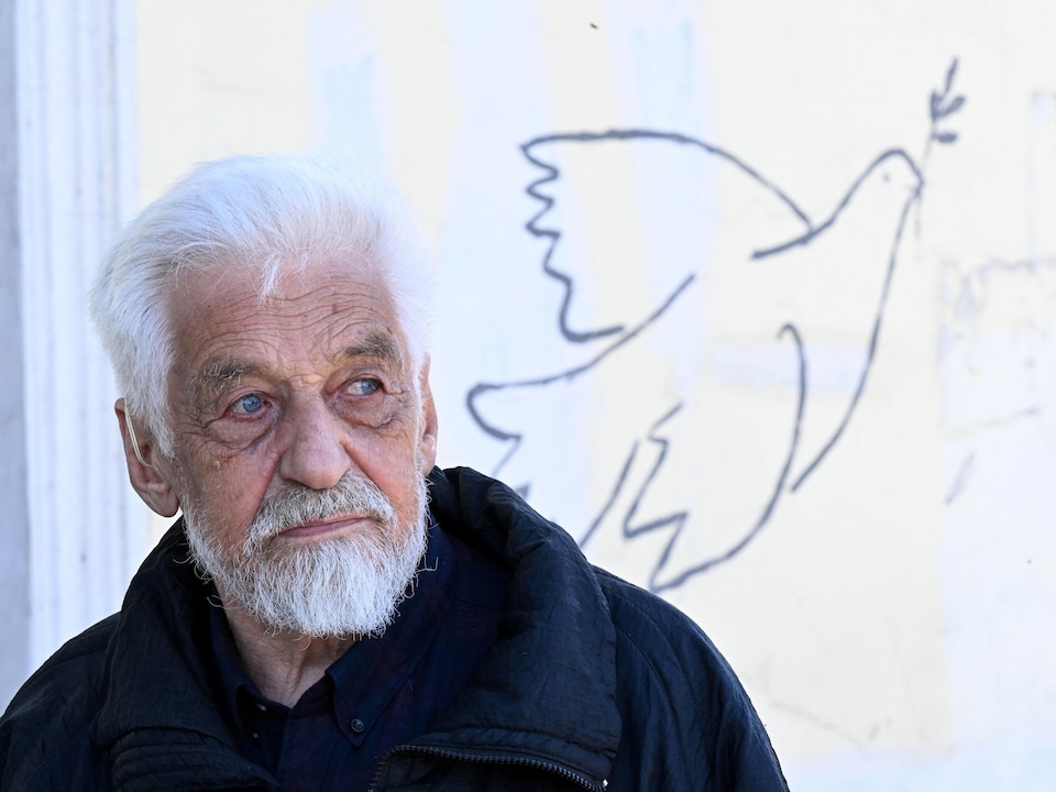 Mr. Ovchinnikov in front of a drawing of a dove of peace.