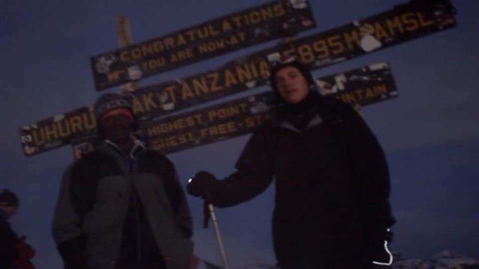 Two men on top of Mount Kilimanjaro. 