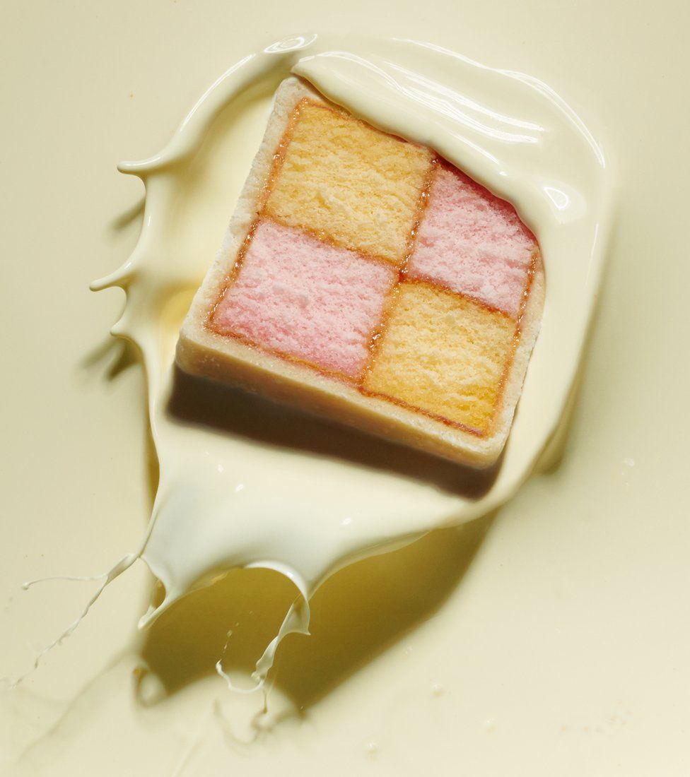 A Battenberg cake dropped into cream