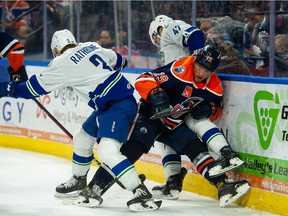 Abbotsford Canucks defenseman Jack Rathbone battles for the puck against a Bakersfield Condors defender during Game 2 of their best-of-three opening round AHL playoff series.