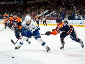 Abbotsford Canucks forward Vasily Podkolzin carries the puck against two Bakersfield Condors defenders during Game 2 of their best-of-three opening round AHL playoff series.