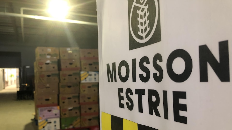 A Moisson Estrie poster in front of a room full of boxes. 