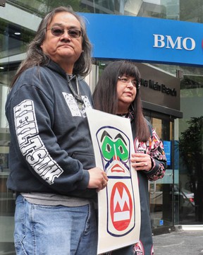 Maxwell Johnson with Heiltsuk Chief Marilyn Slett in front of the Burrard Street branch of the Bank of Montreal.