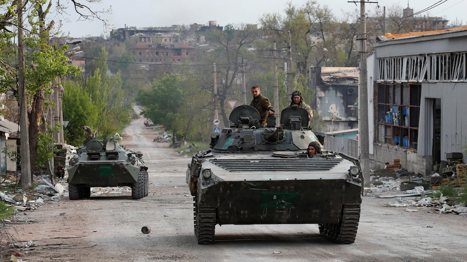 Two Pro-Russian tanks on a street in Mariupol where all the buildings are destroyed.