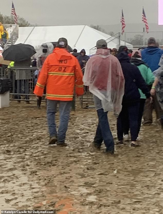 Pennsylvanians are split on Oz, claiming they are unsure about his candidacy for Senate considering he is not a native of the Keystone State. Here a pro-Trump rally attendee wears an orange rain coat with the letters 'No Oz' taped to the back