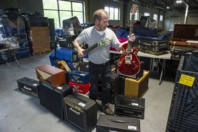 Rod Davis, warehouse manager for Able Auctions, with some of the hundreds of guitars and amplifiers and effects pedals that will be auctioned by Able in the near future.  The collection was owned by one person.