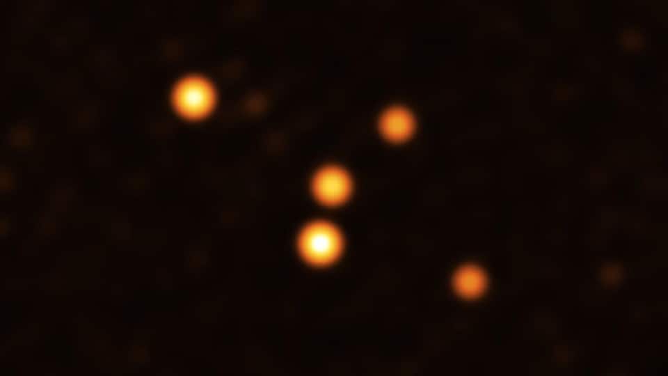 Five orange dots on a black background.  The image shows stars orbiting very close to Sgr A* (center), the supermassive black hole at the heart of the Milky Way.