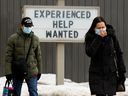 Pedestrians make their way past a help wanted sign at a Jiffy Lube location, 9927 82 Ave., in Edmonton, on Tuesday March 15, 2022. 