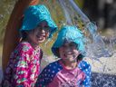 Sara Gentile, 7, and her sister Abigail, 5, keep cool under a cone of water at the splash pad at Valois Park in Pointe-Claire.