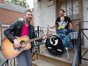 Noah Sidel, with his son Elijah on his lap, and Audiocassette bandmate Charles Houle play some music on sidel's front porch in NDG on Thursday.  Audiocassette will be hosting the final event of Porchfest in NDG, including a charity BBQ.  
