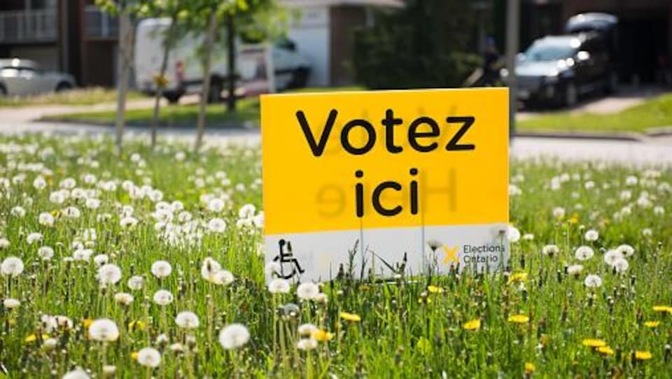 A sign announcing a polling station planted in the lawn