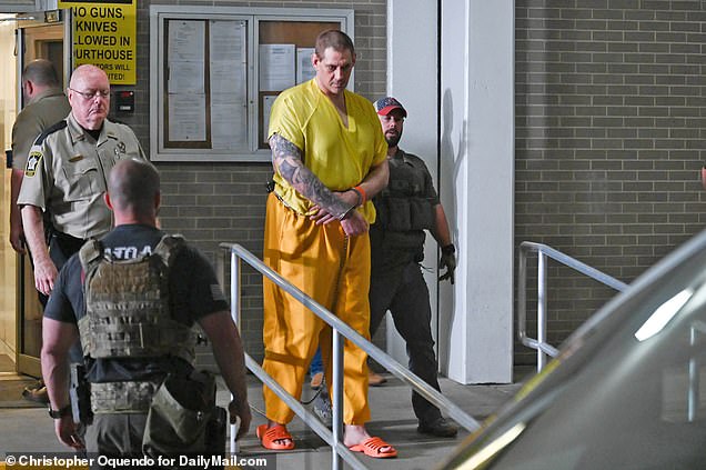 Casey White, who is 6ft 9 tall, is seen towering over the guards in Alabama