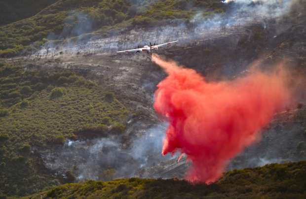 Firefighter drop retardant in Aliso Canyon during the Coastal Fire...