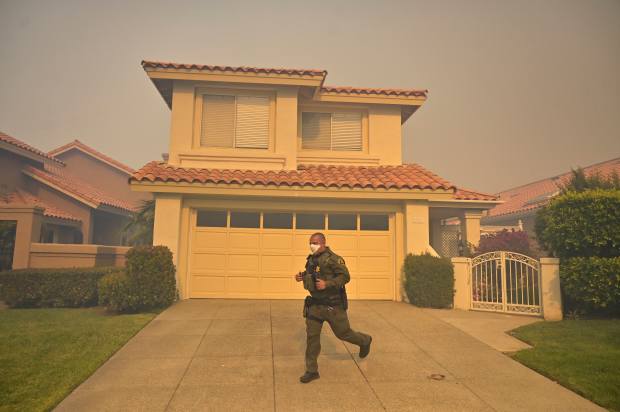 An Orange County Sheriff Deputy runs from house to house...