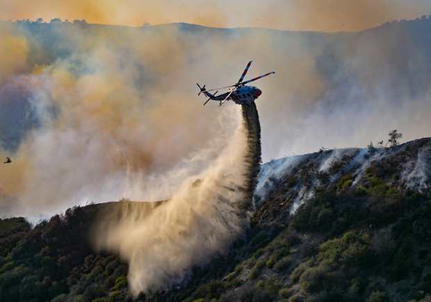 Firefighter drop water in Aliso Canyon during the Coastal Fire...