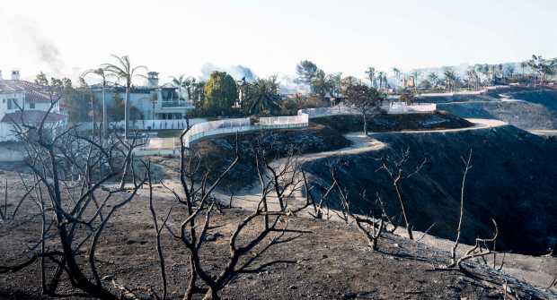 Homes continue to smolder on Coronado Pointe after the Coastal...