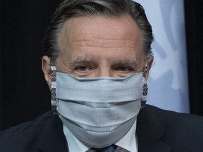 Premier François Legault arrives at a news conference on the COVID-19 pandemic wearing a mask, Tuesday, May 12, 2020 at the legislature in Quebec City.