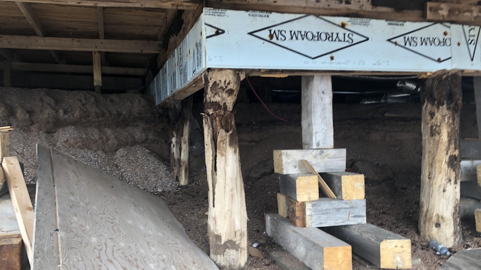 Close-up of beams that support the house in the basement.