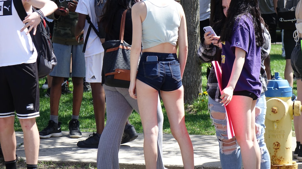 Two young girls are wearing pants that are too short.