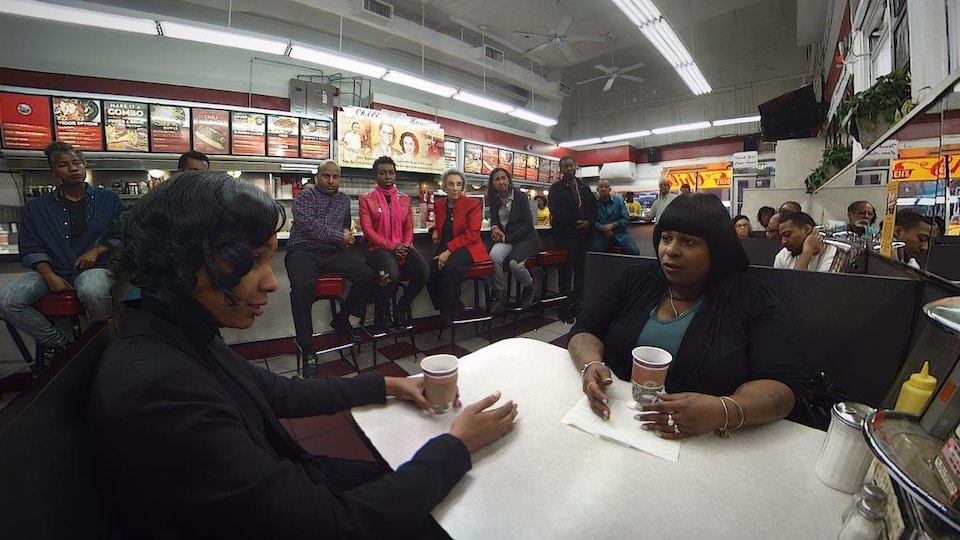 Samaria Rice, Tamir Rice's mother, chats with another person over coffee in a restaurant. 