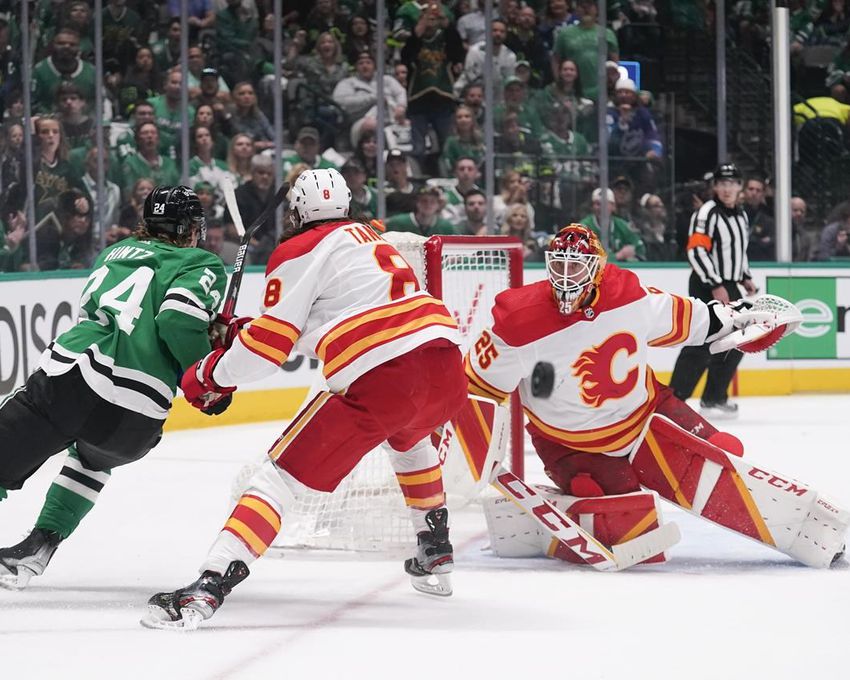 Dallas Stars center Roope Hintz (24) attacks as Calgary Flames defenseman Christopher Tanev (8) and goalie Jacob Markstrom (25) guard their net during the first period of Game 6 of a NHL hockey Stanley Cup first round playoff series, Friday, May 13, 2022, in Dallas.