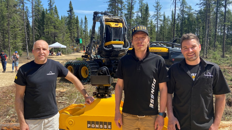 Three man standing in front of a forest machine