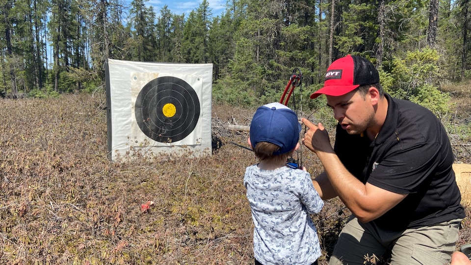 Alexandre Dupuis teaches the basics of archery to a young visitor.
